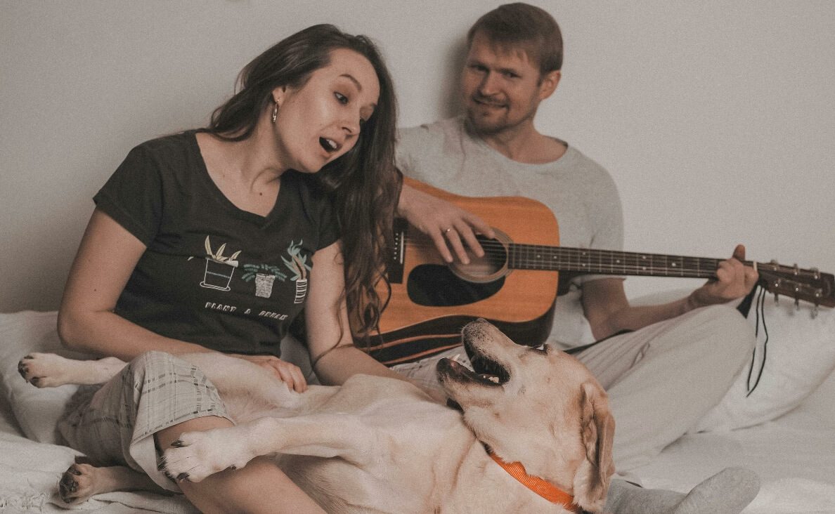 DO DOGS LIKE MUSIC - man playing a guitar, woman singing to lab dog