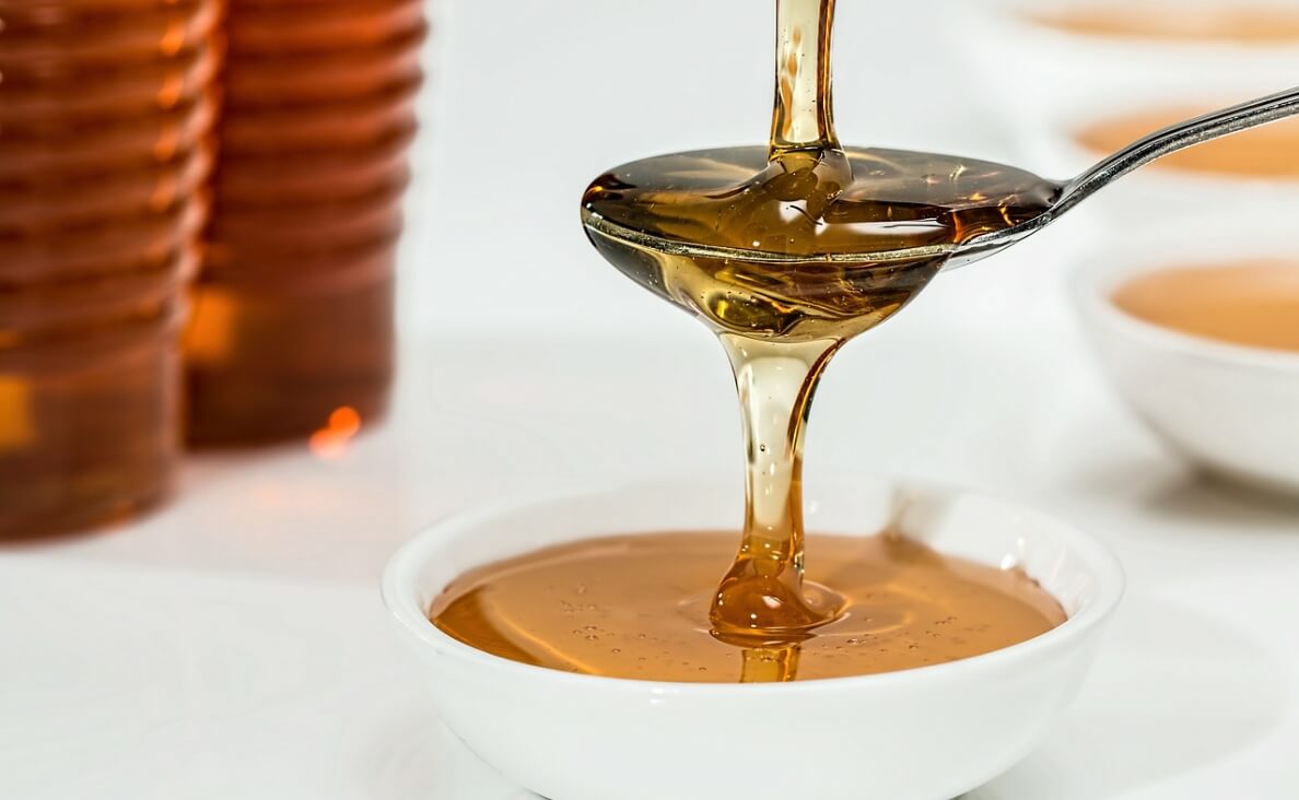  Can Dogs Eat Honey - honey being poured over spoon and bowl